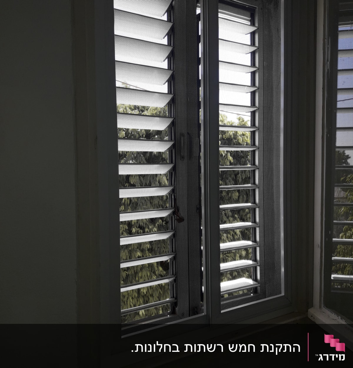 חלון עם תריסי אלומיניום פתוחים חלקית